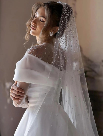 White formal headpiece A-line phantom collar with long floor length and ruffled bead embellishments